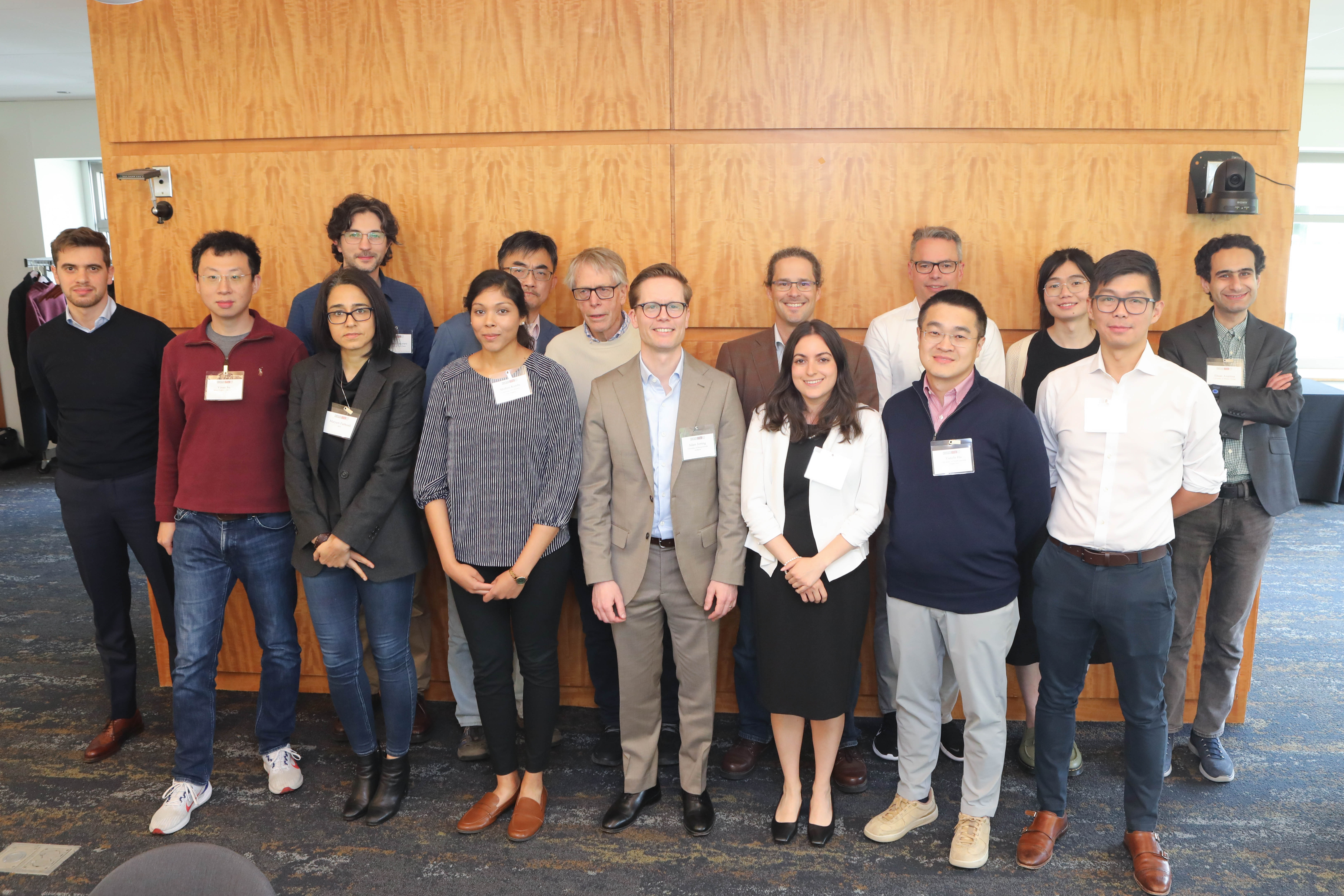 Picture of yiran fan prize winners, conference attendees, and faculty standing together in front of a tan background. 