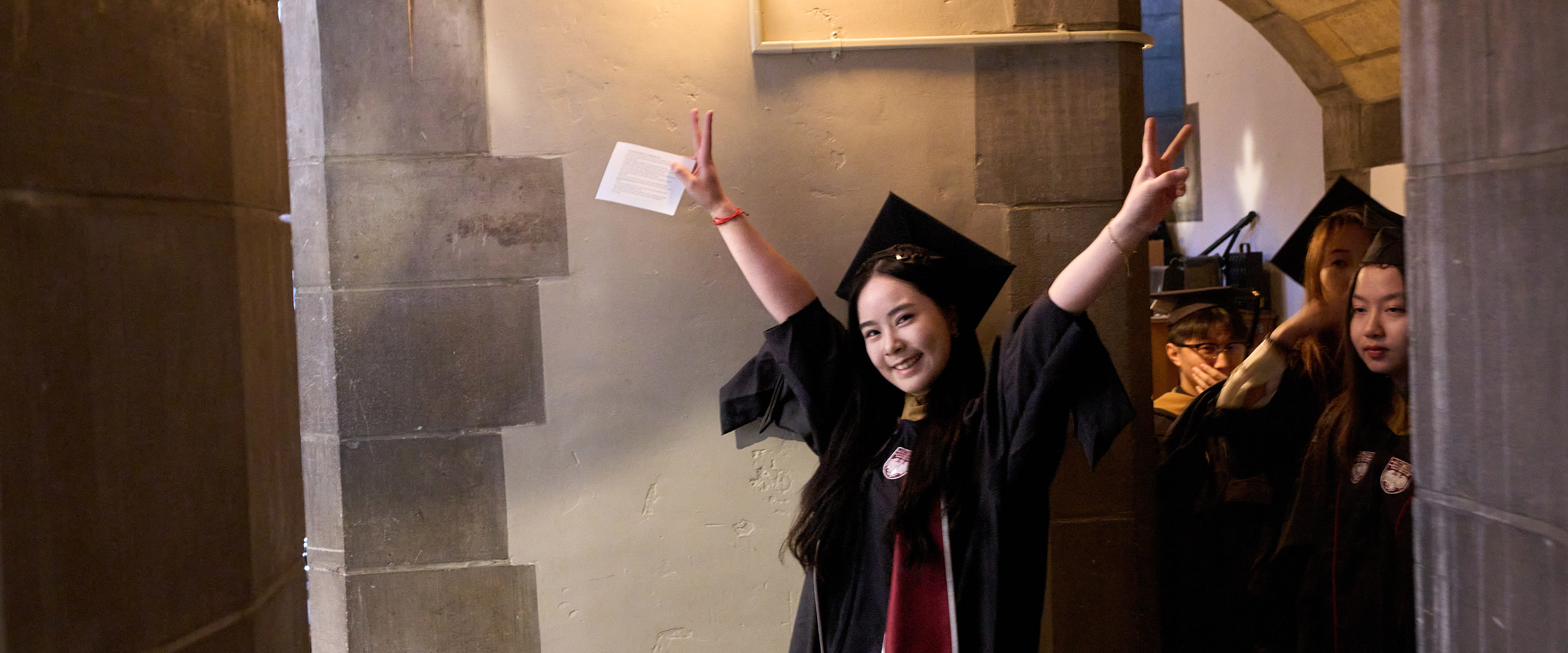 Student smiling at camera during graduation. 
