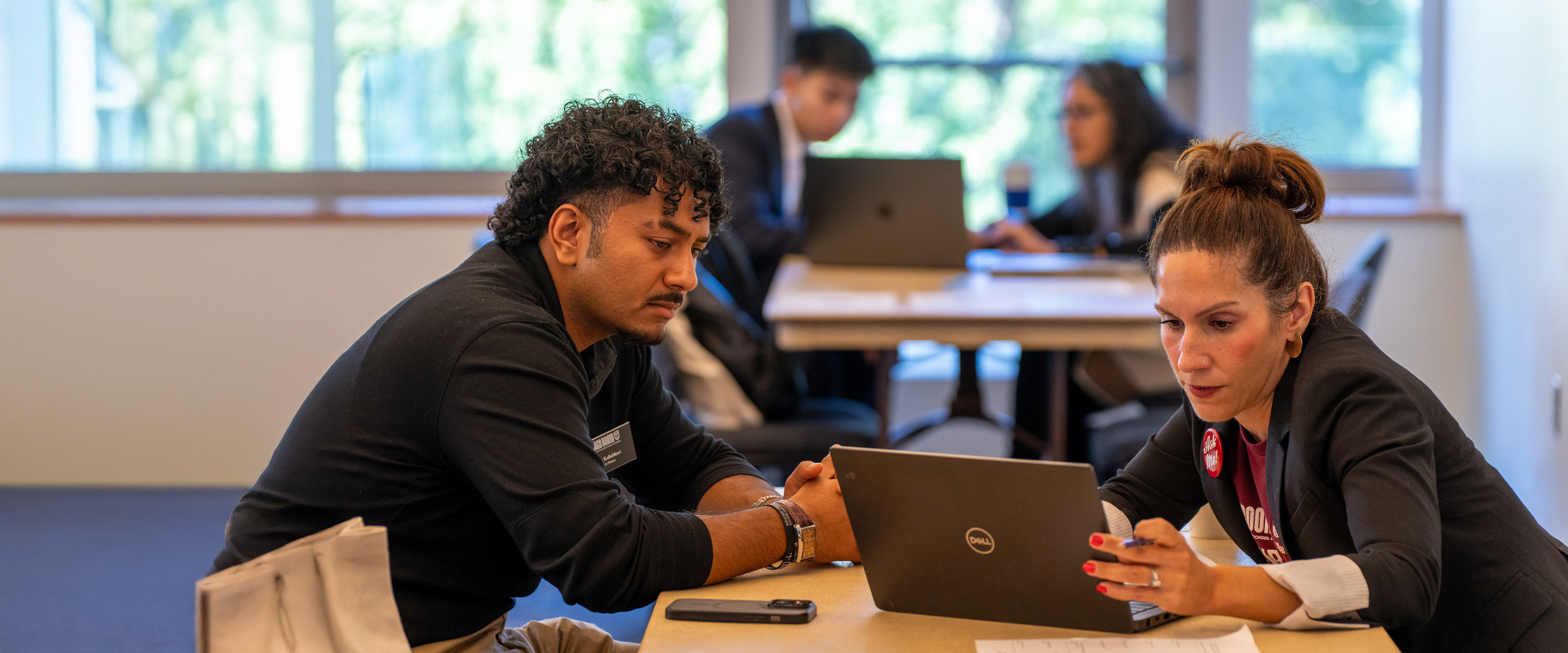 Student and staff looking at computer.