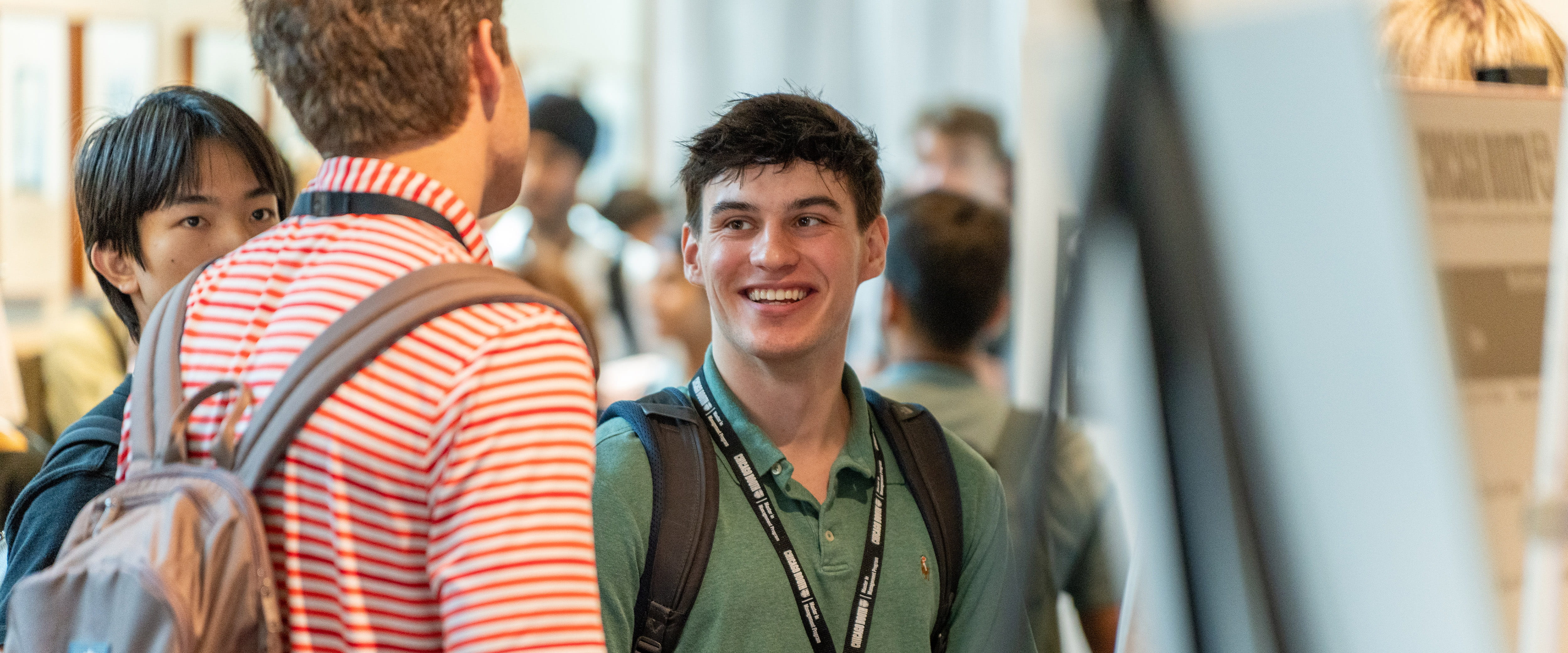 Student smiling at another student socializing. 