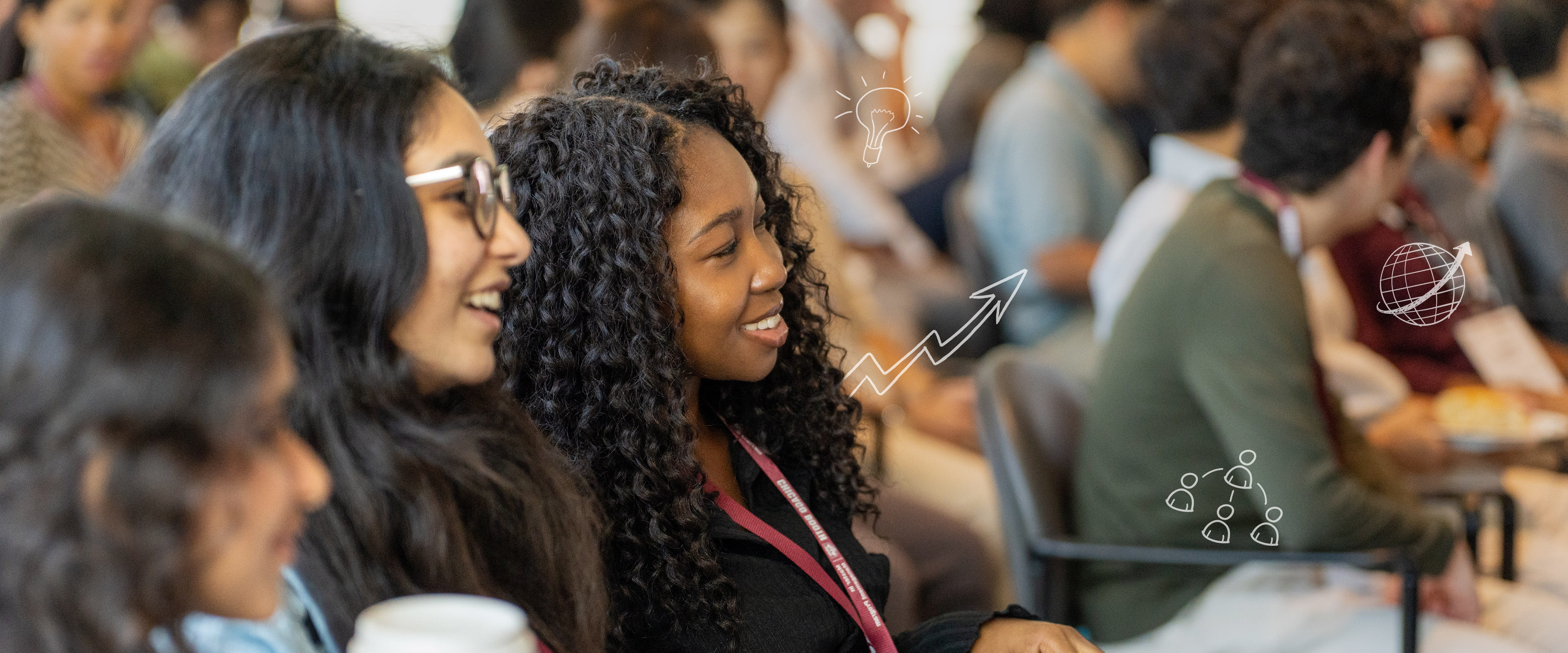 Students smiling as they listen at an event.