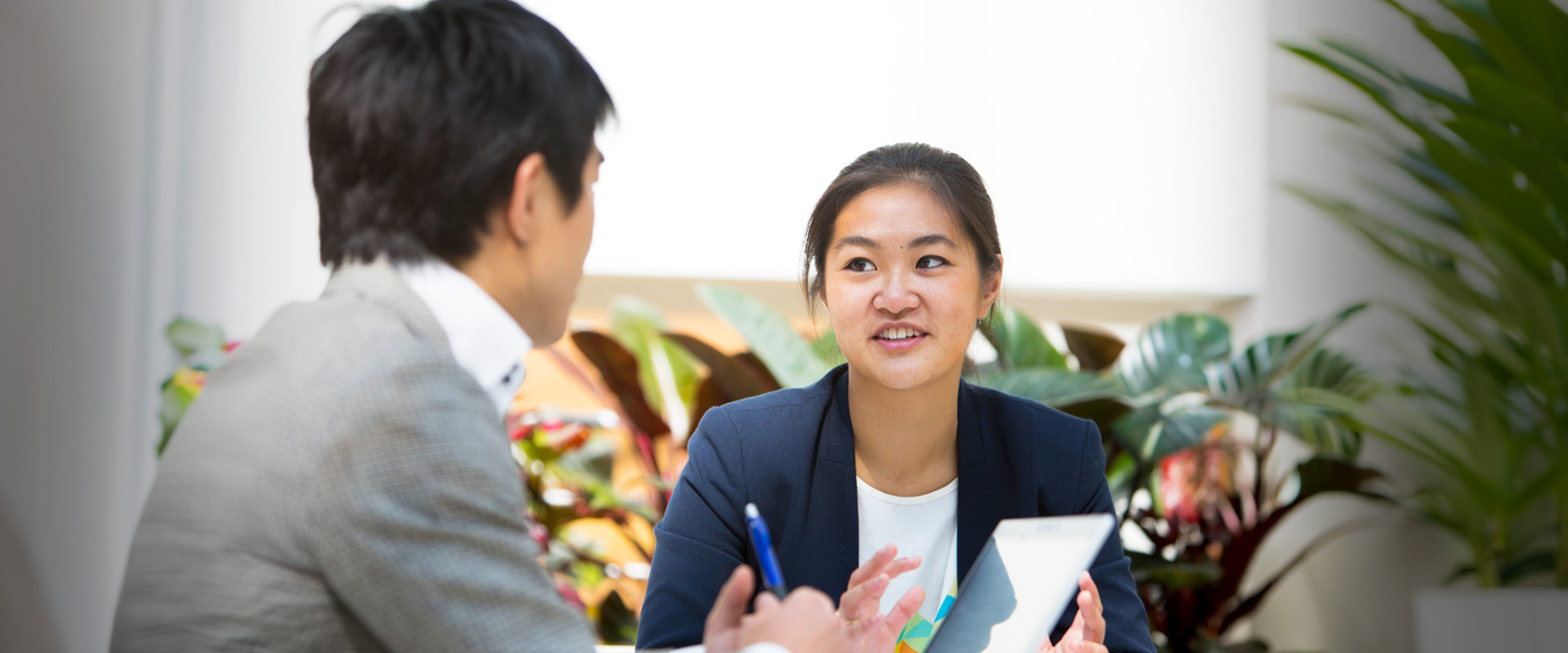 A student in formal-wear has a conversation with a colleague.
