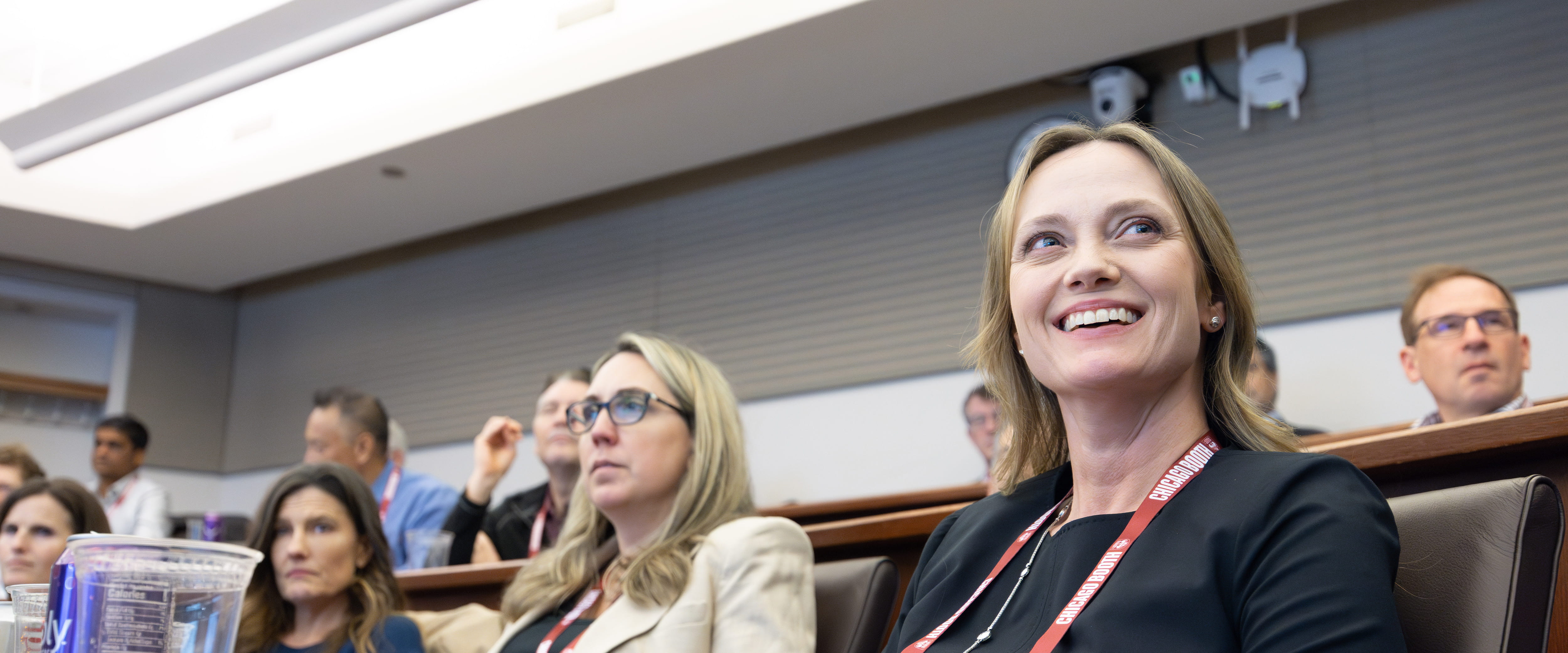 A student in side profile watching a presentation in a classroom.