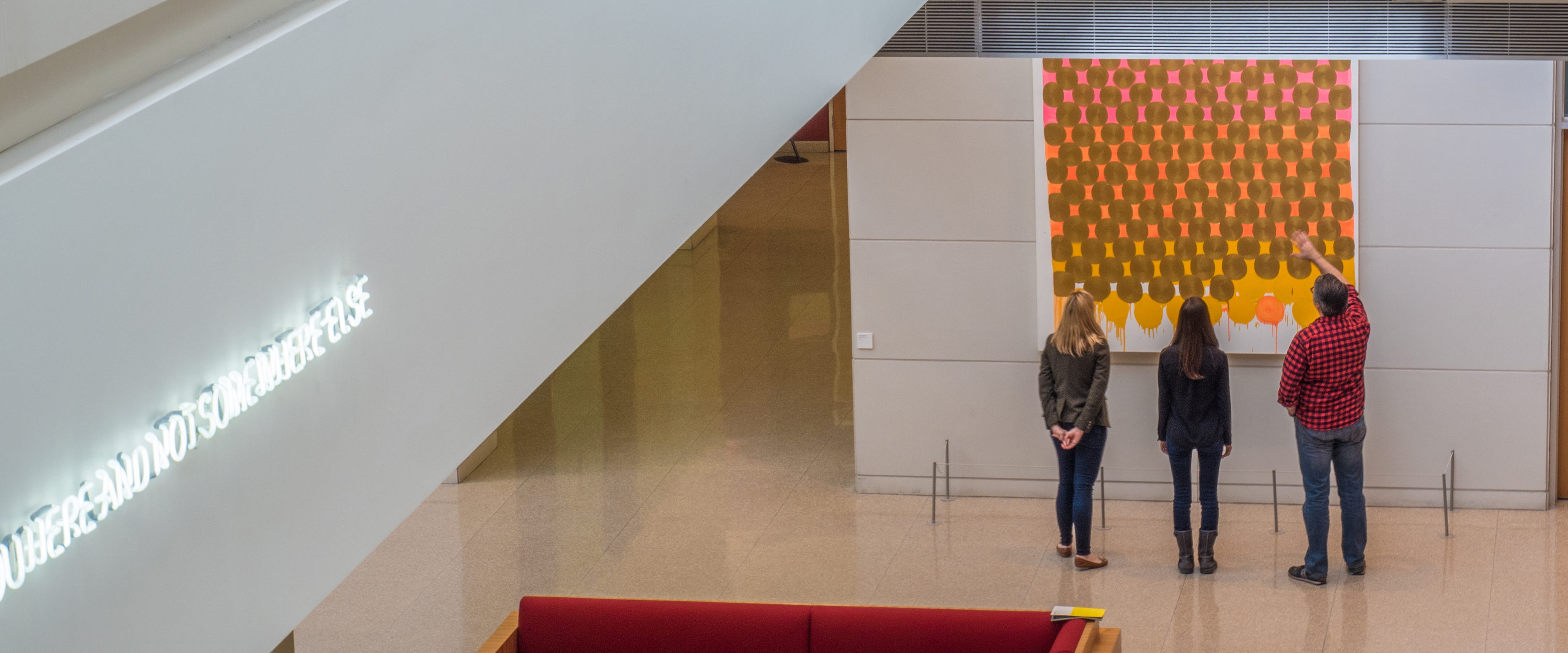 students looking at the art on the wall in Harper Center