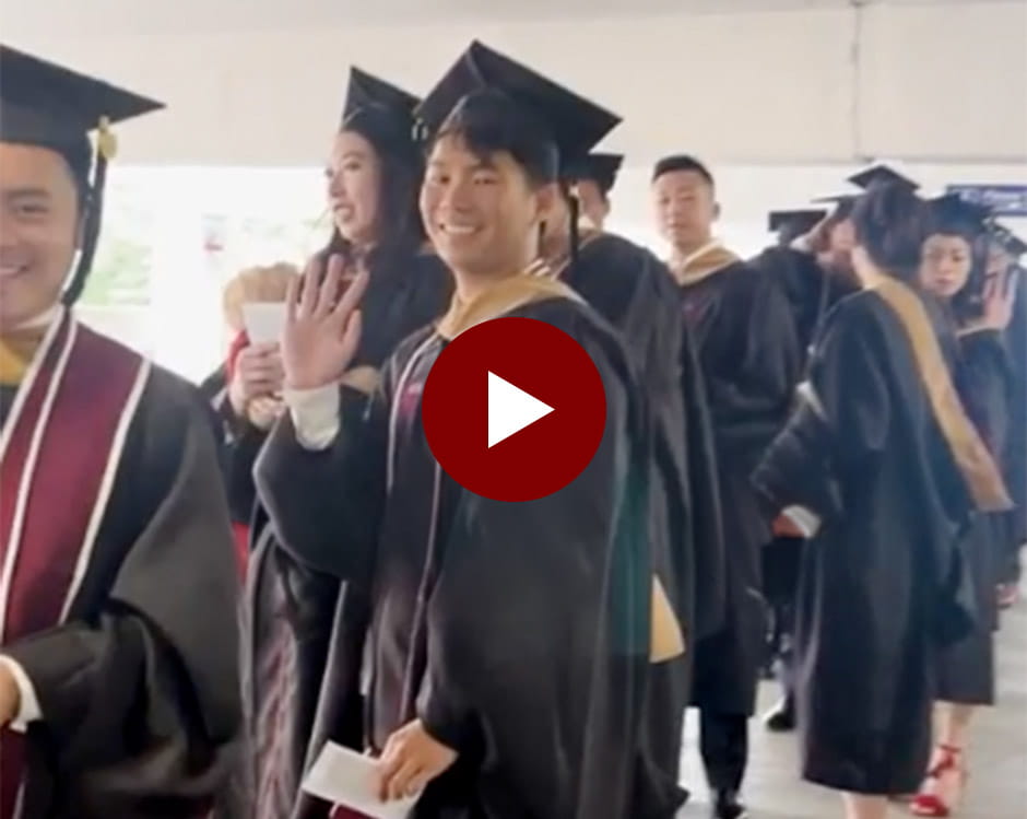 A graduate waving.