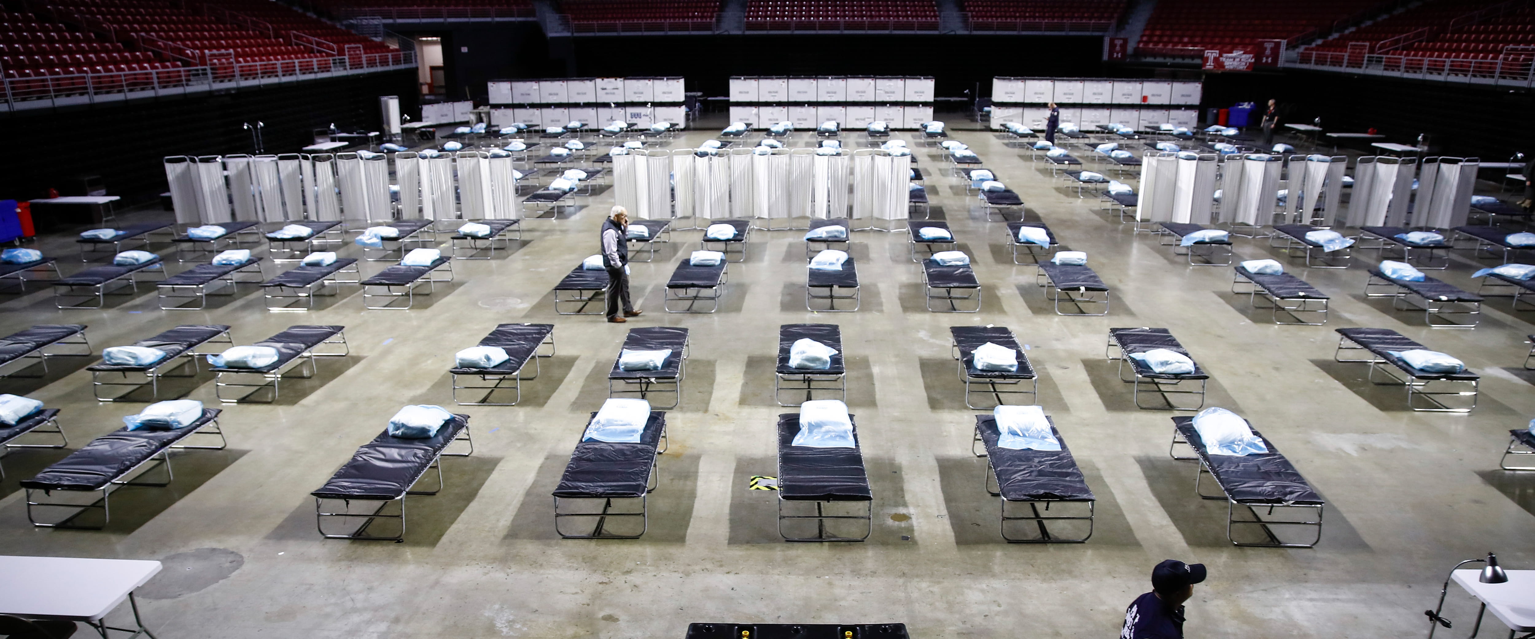 A person walking through an empty field hospital 