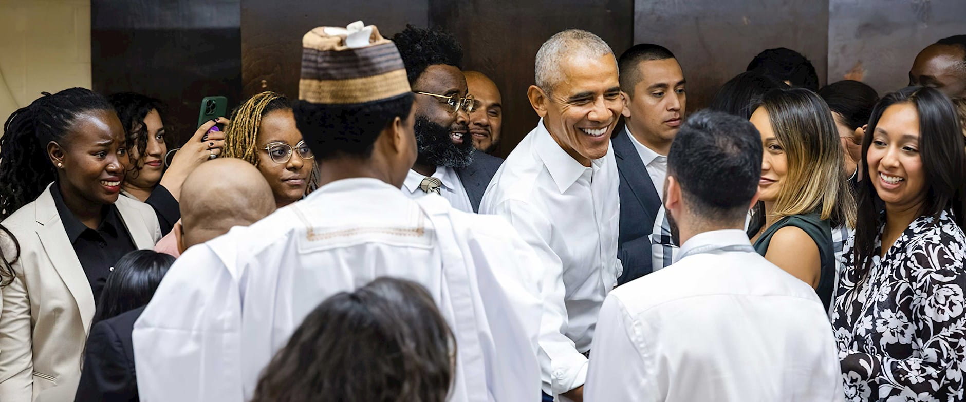 Barak Obama shaking hands with a group of Obama Scholars