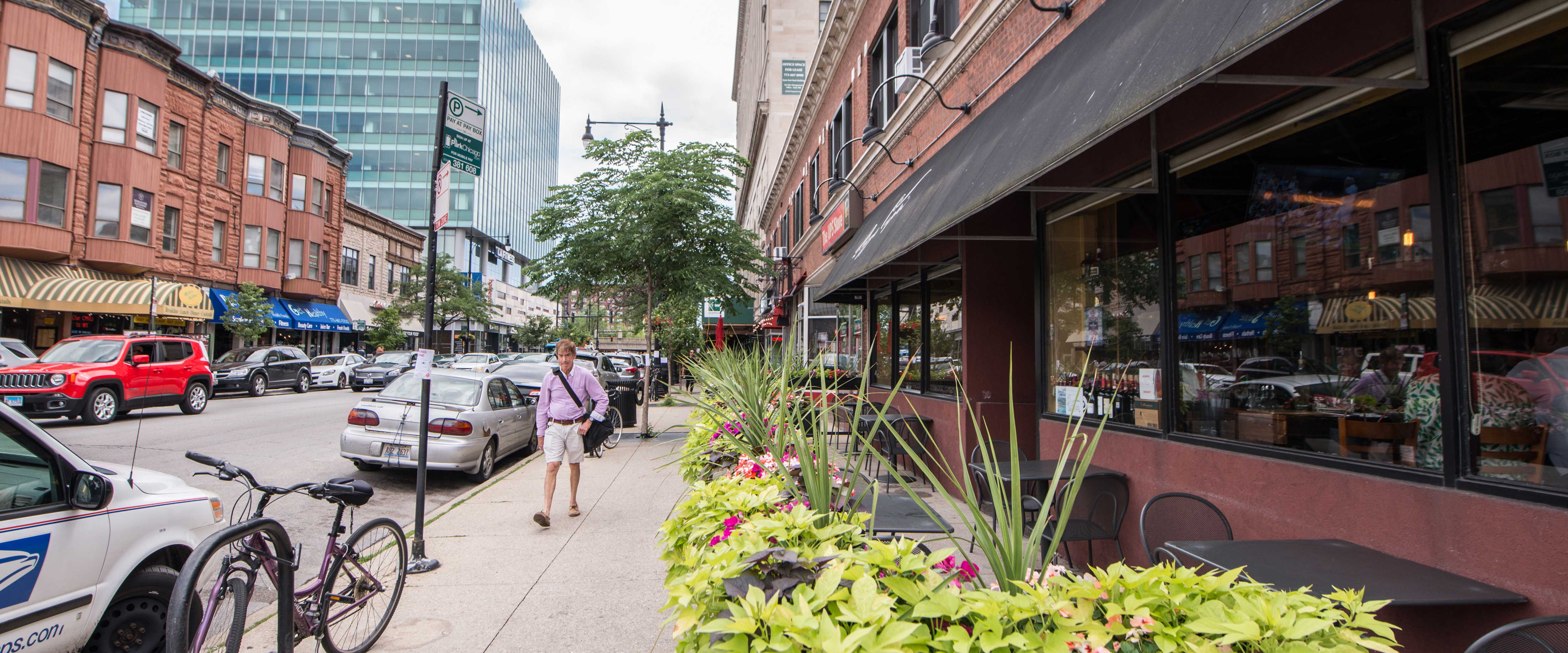 A man walking down a street of stores in Hyde Park