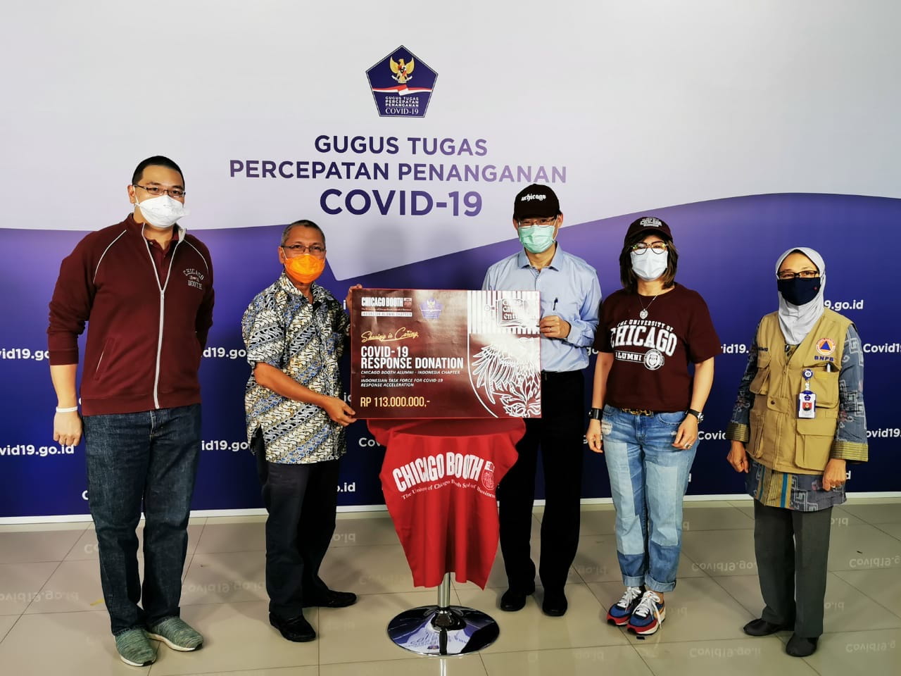 Members of the alumni club of Indonesia pose with a donation for COVID relief efforts