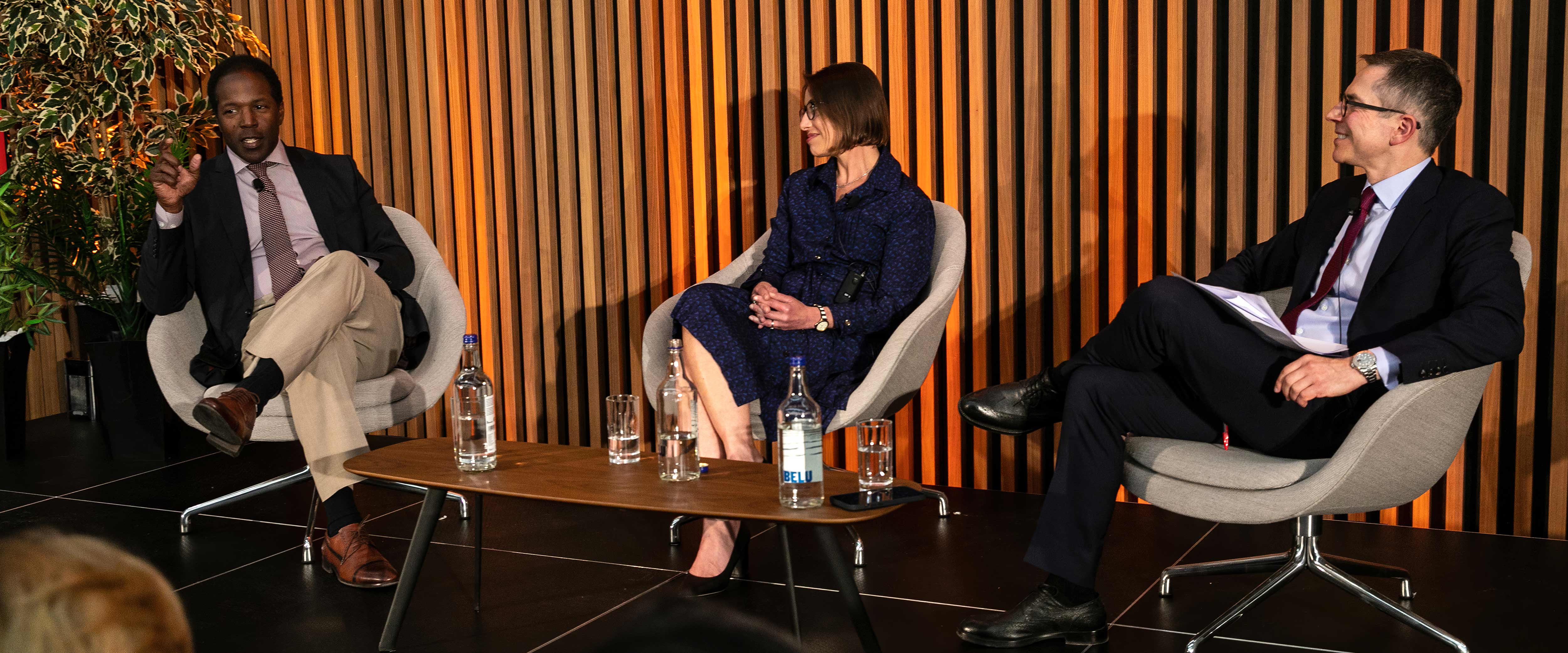 Derek R. B. Douglas, Caroline Grossman, Randall S. Kroszner on stage during a panel discussion