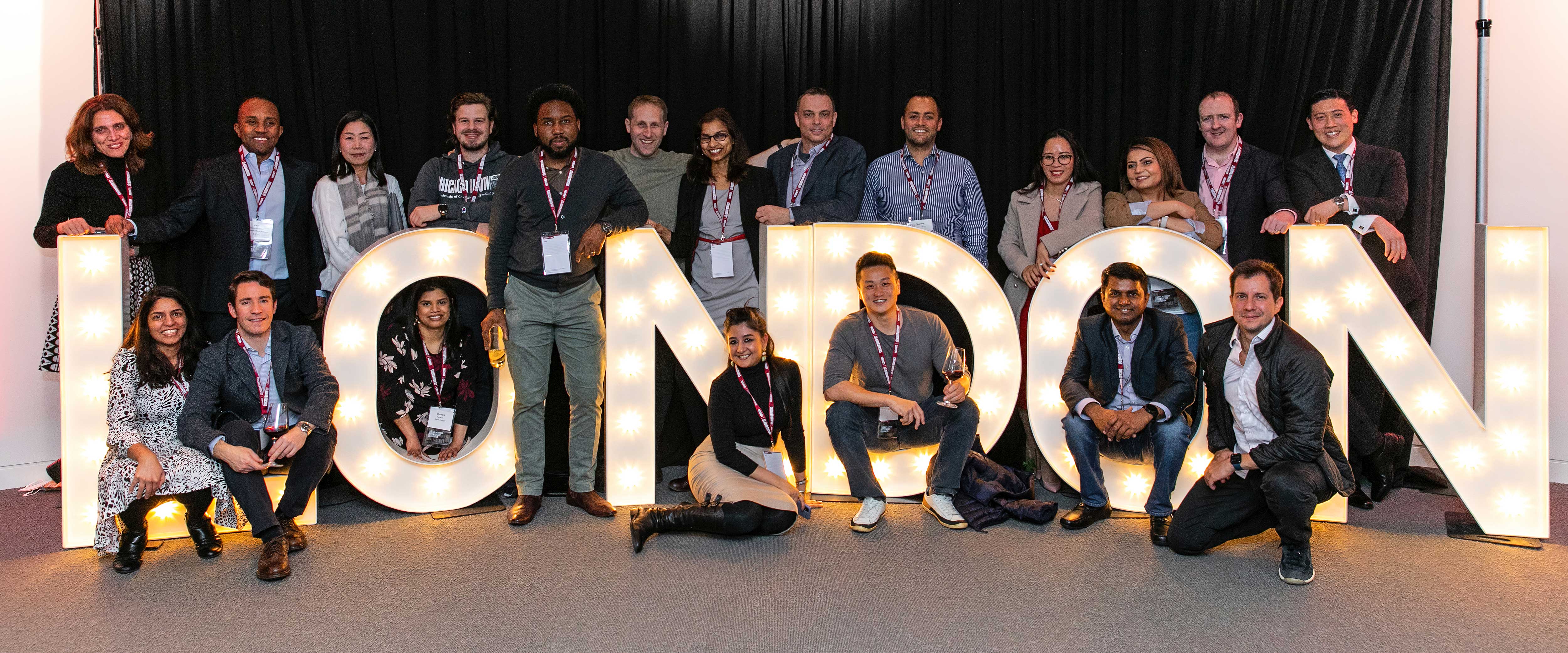 Giant lights spell out "London" as people pose beind and in front of the light-up letters, 28 March 2022