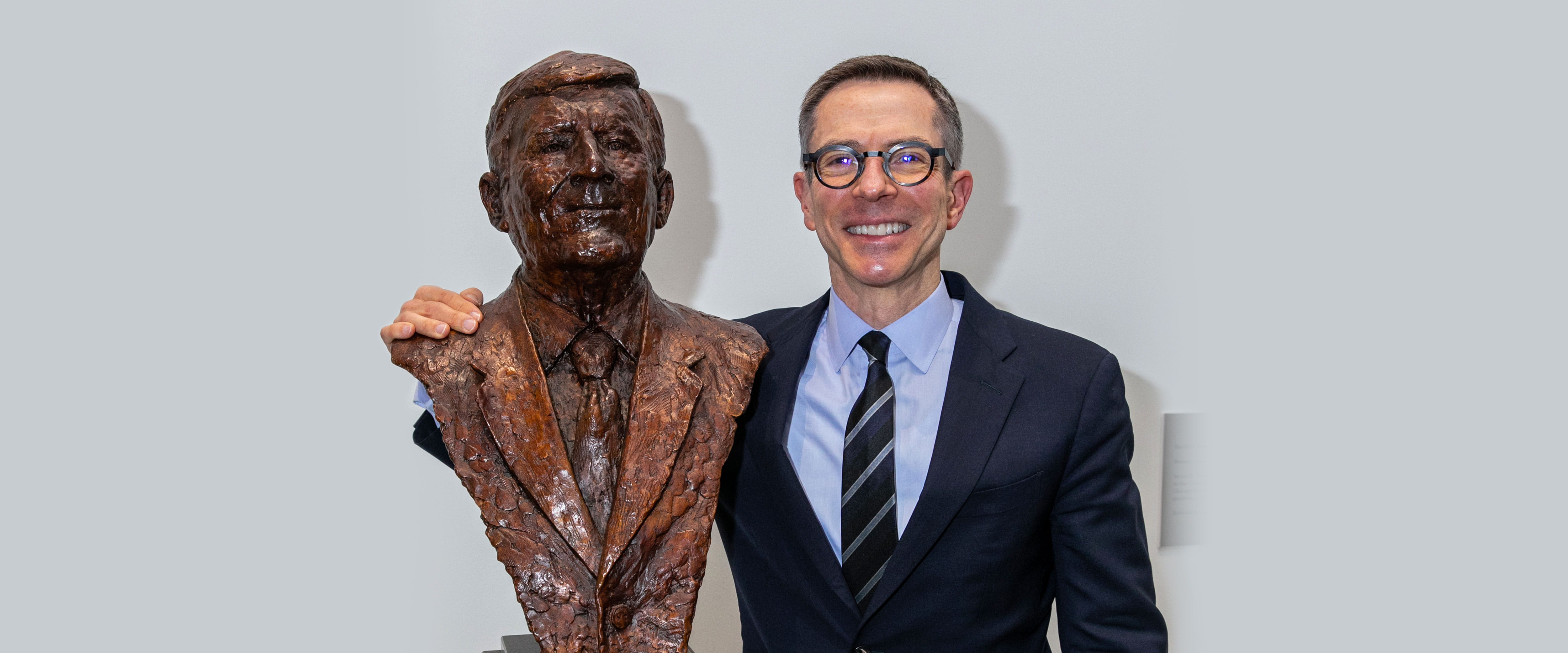 Randy Kroszner poses with a statue of David Booth