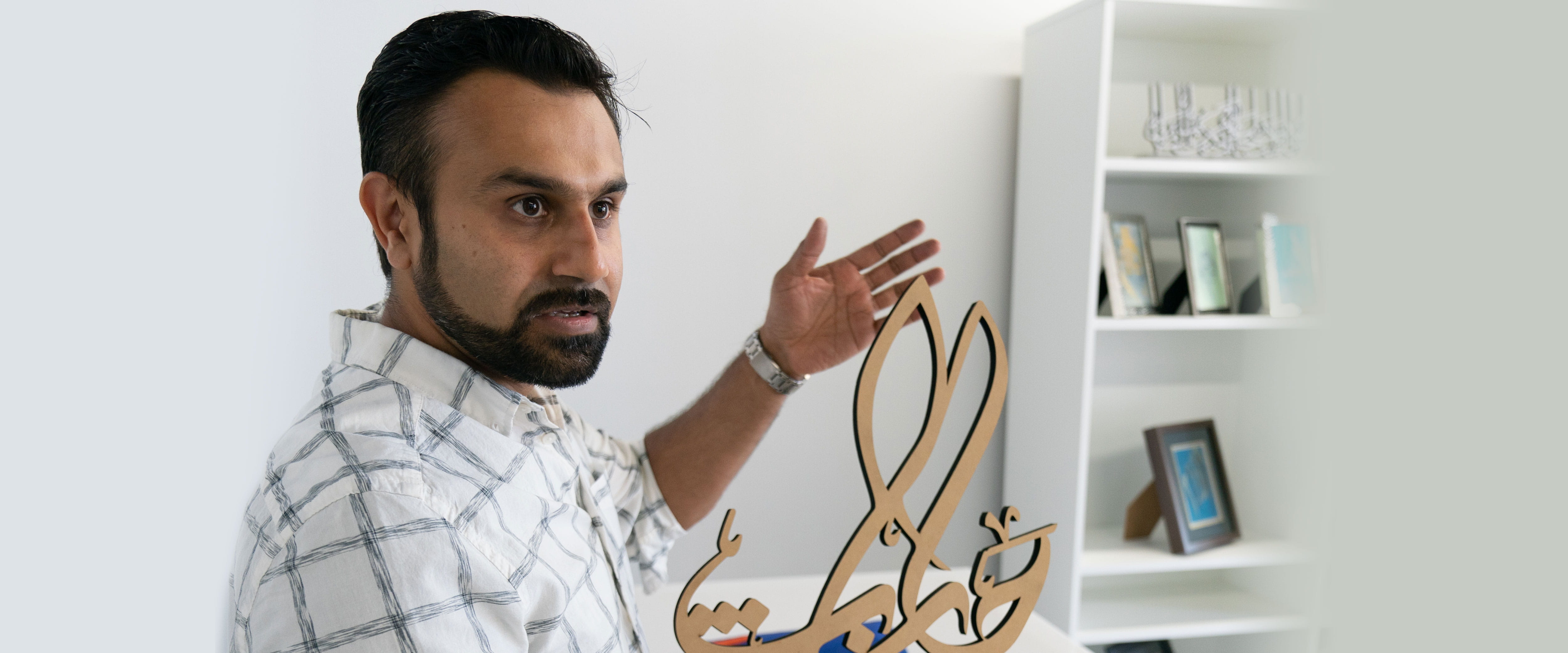 Zeeshan Farooq explaining a piece of laser cut art