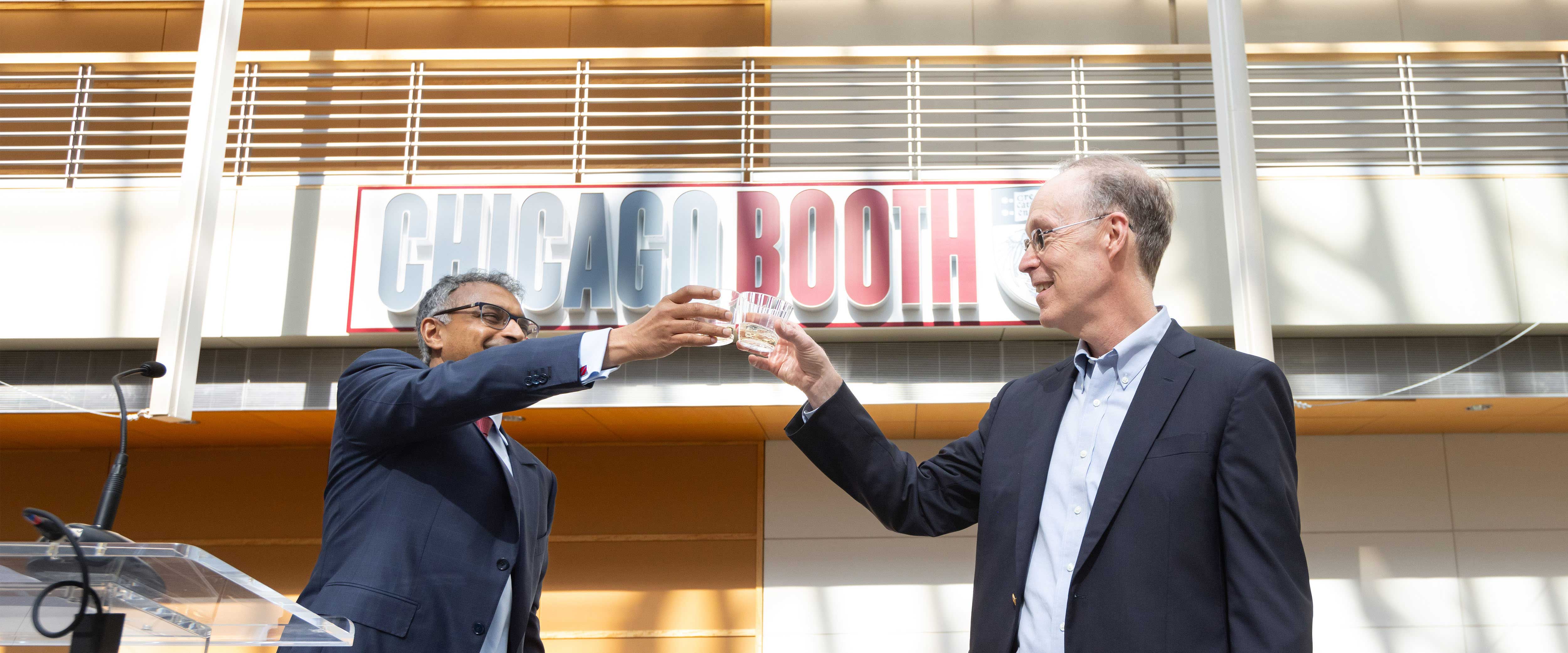 Douglas Diamond rasies a glass of champagne with Madhav Rajan. 