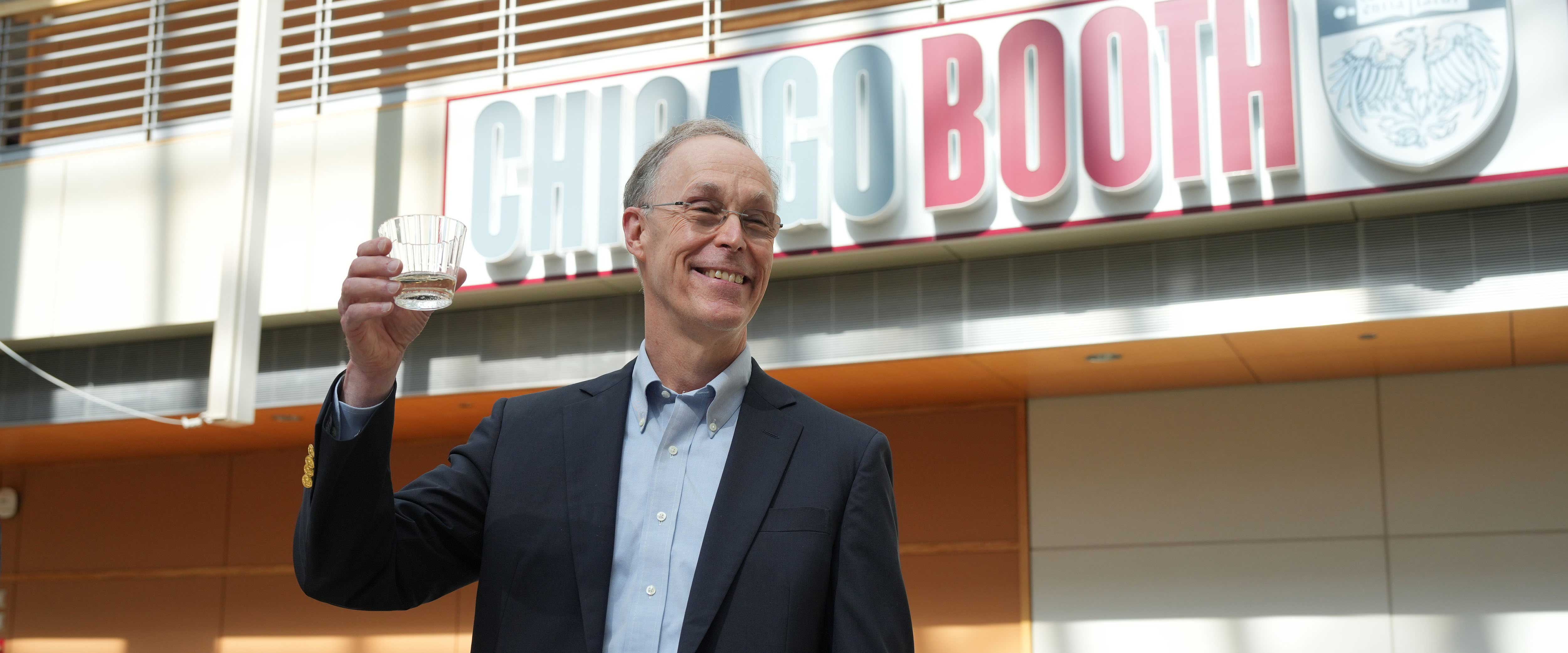 Douglas Diamond rasies a glass of champagne with members of the community. 