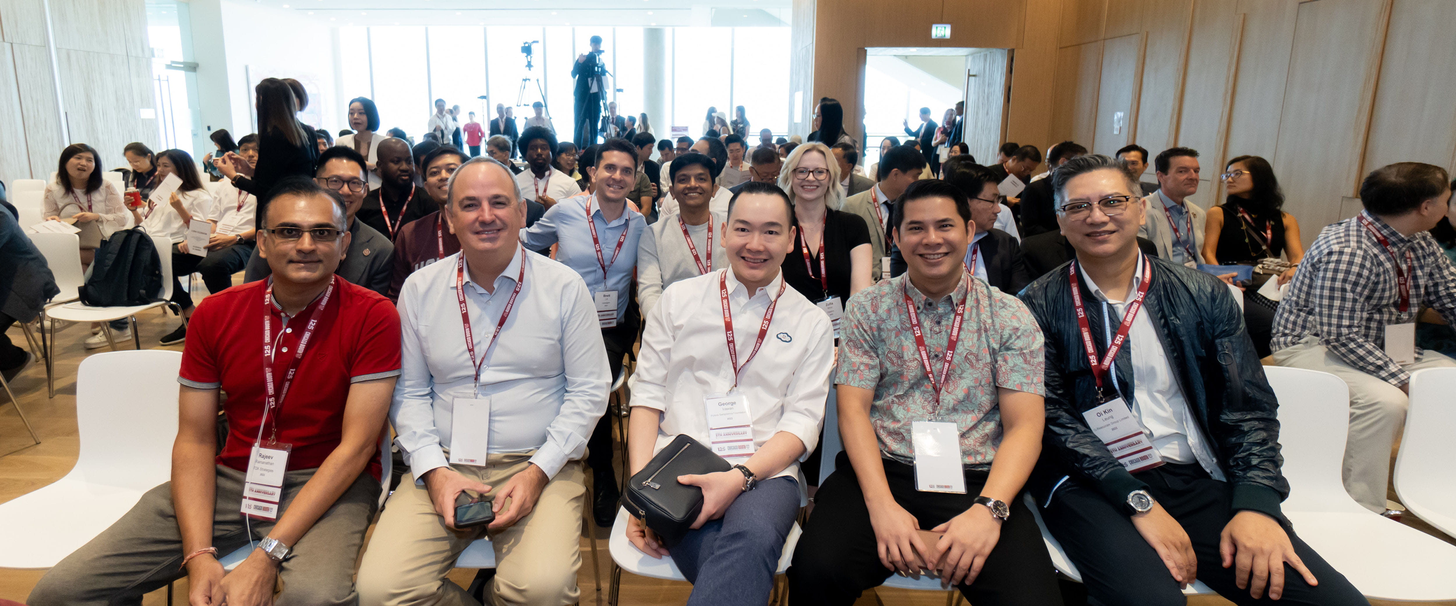 Booth Hong Kong students and faculty smiling for the camera in an audience