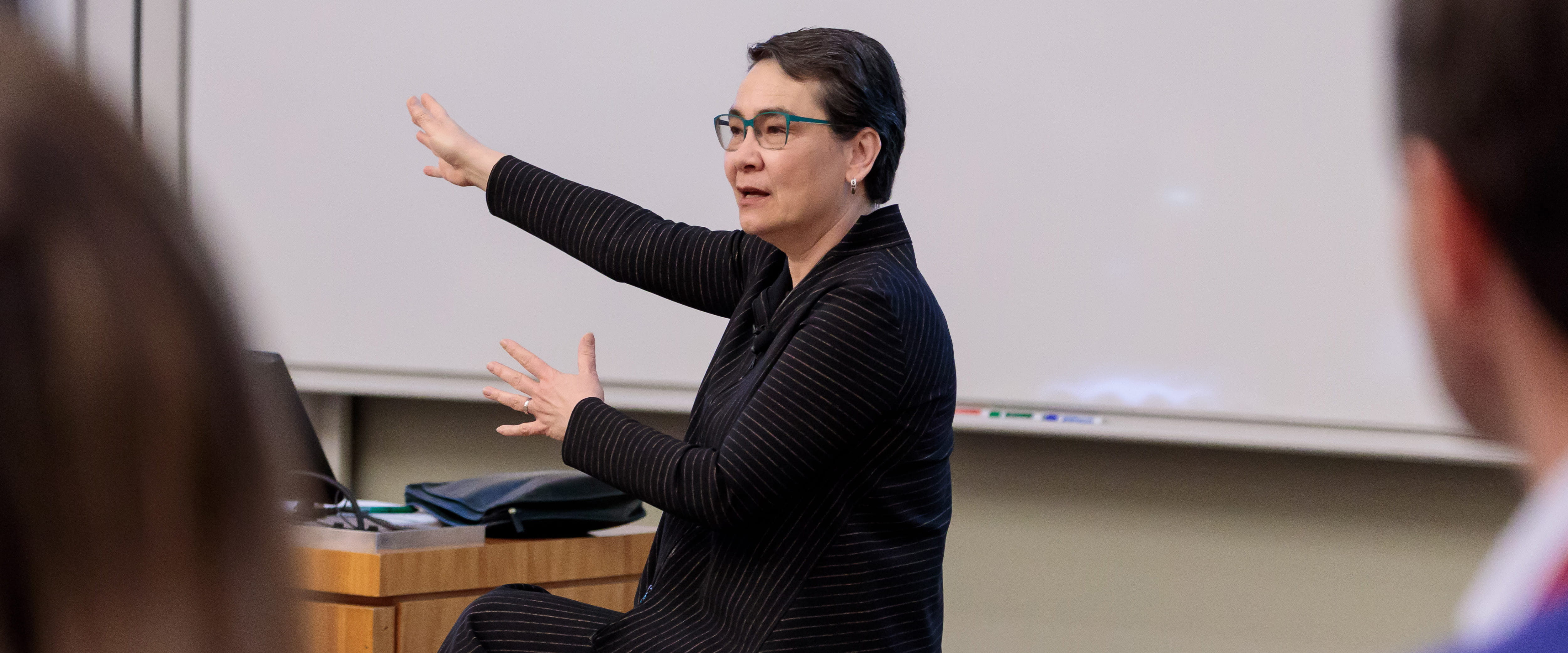 Professor Linda Ginzel teaching a class and gesturing to the board