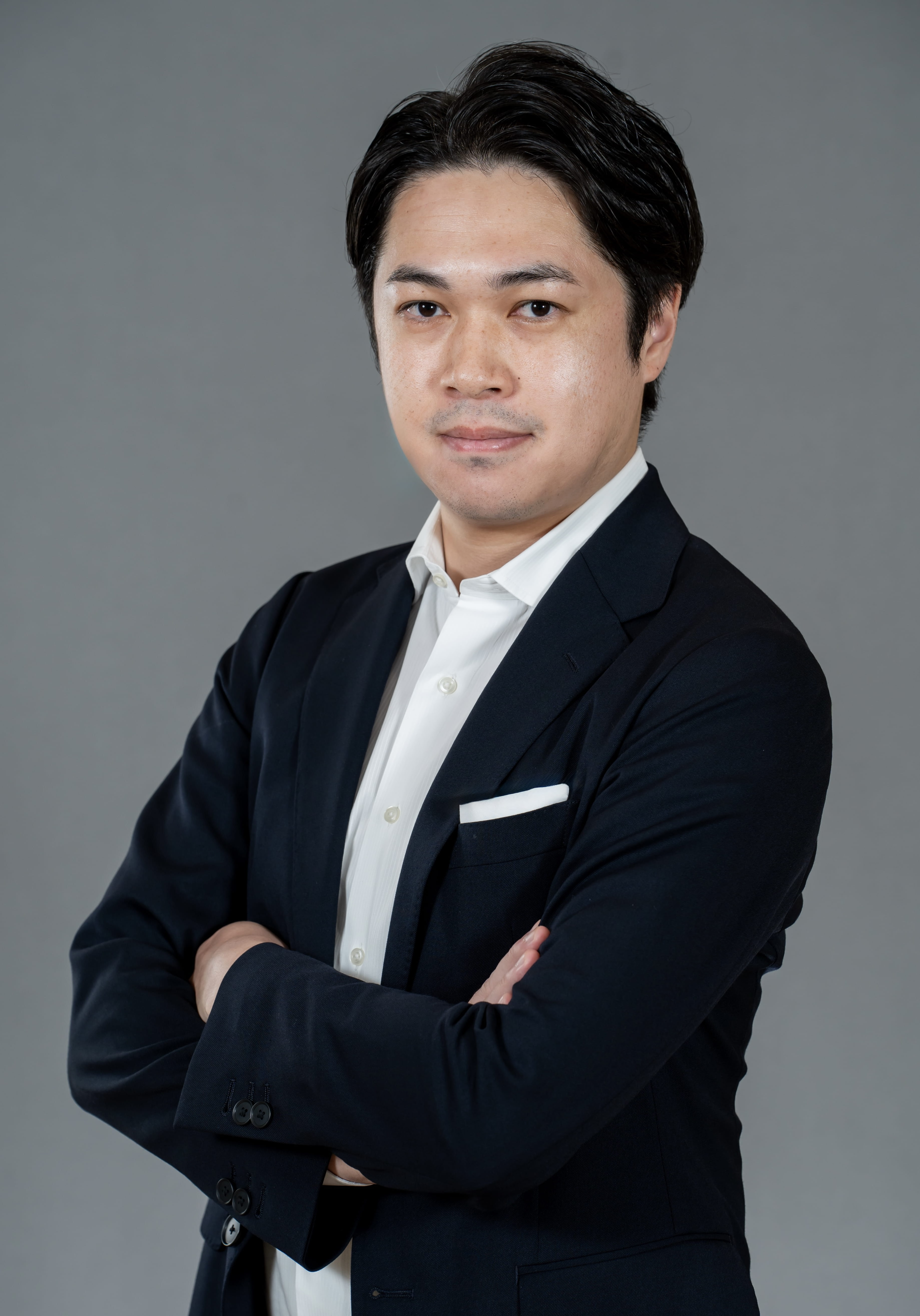 Headshot of a man facing the camera with his arms folded