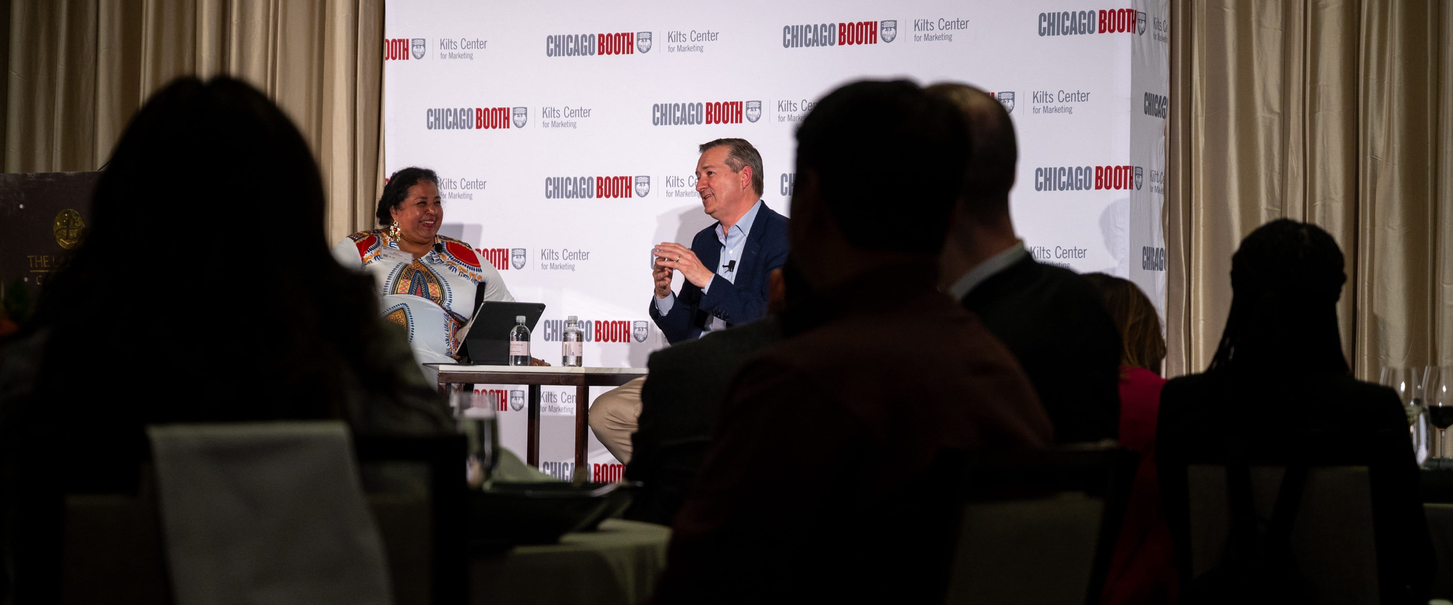 Crowd view of man and woman presenting at summit