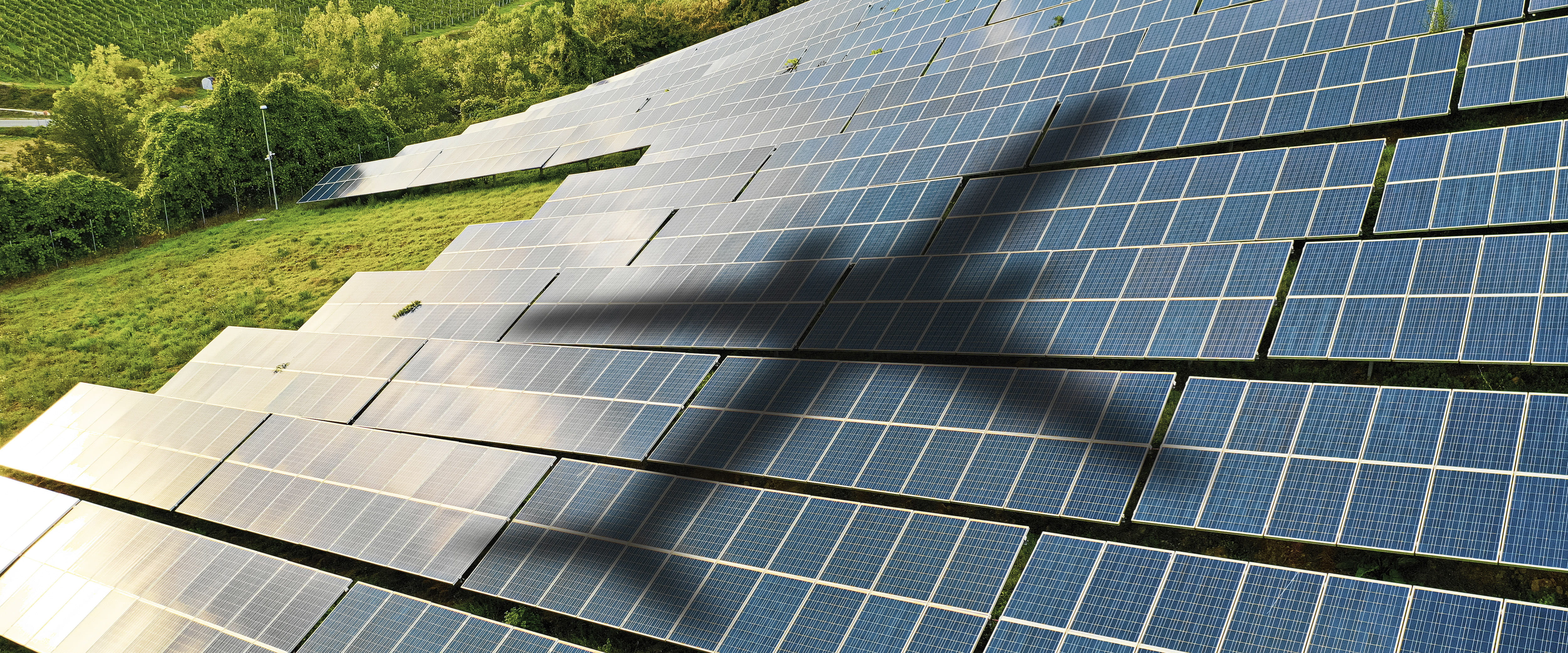 airplane flying over solar panels and greens