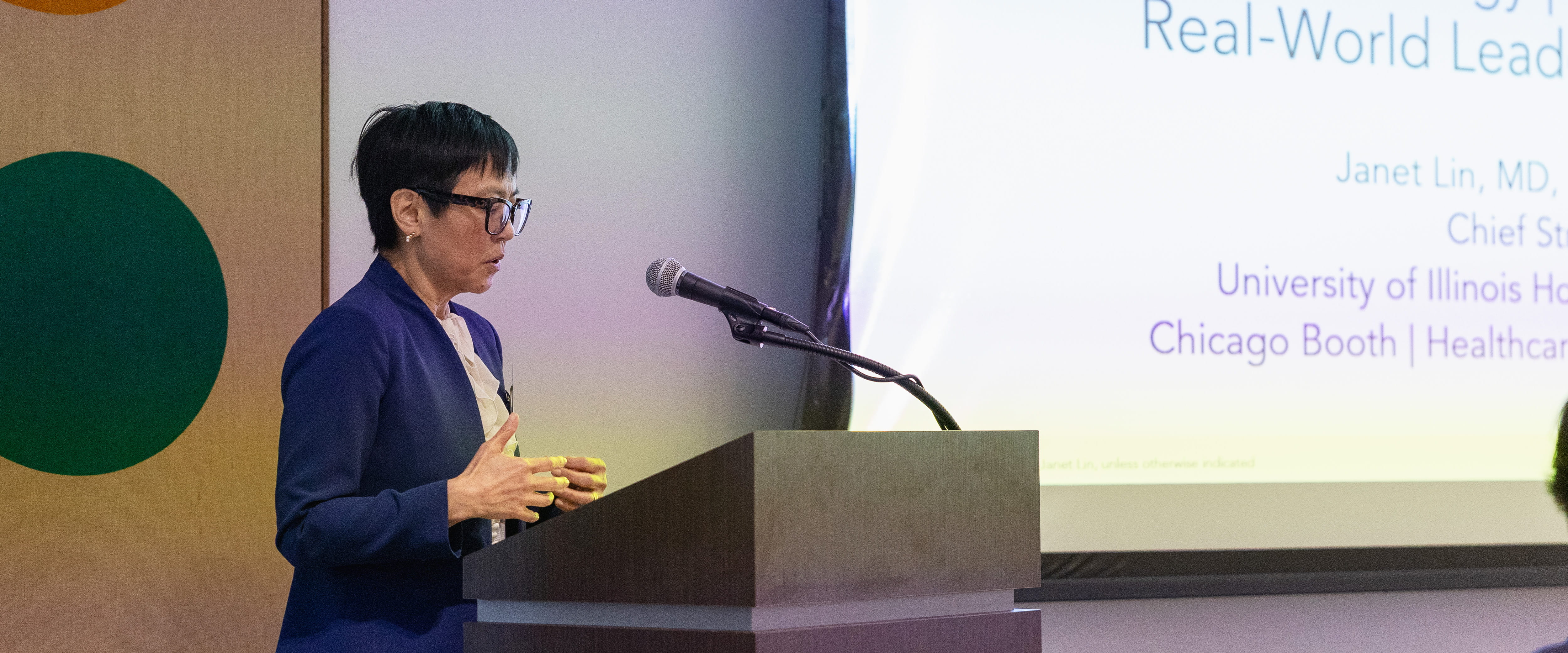 Speaker addressing the audience behind podium 