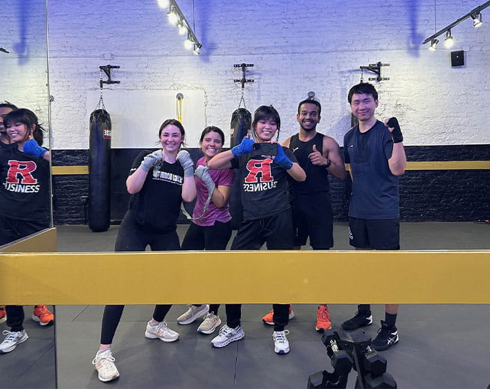 Jenett Cheng and friends facing mirror with phone while at boxing studio