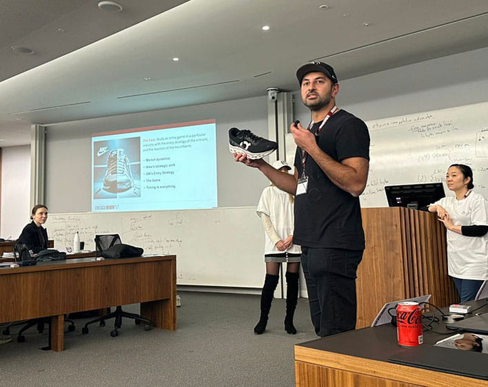 Sharan Chawla presenting in classroom while holding a shoe