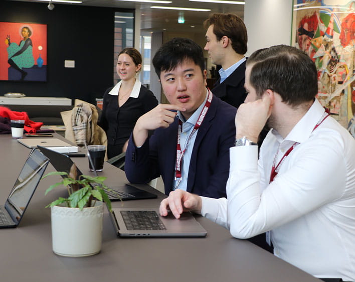 Aiden Cheung talking to classmate while sitting down in chair