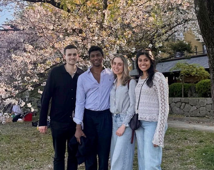 Trisha Atluri with three friends in front of tree smiling