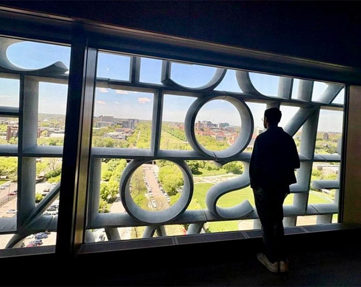 Hashaam Asif inside the Obama Center looking outside