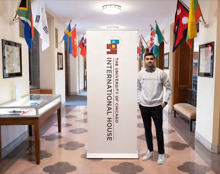 Hashaam Asif in front of UChicago International House sign