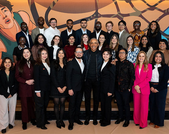 Large group of Obama Scholars smiling with former President Barack Obama
