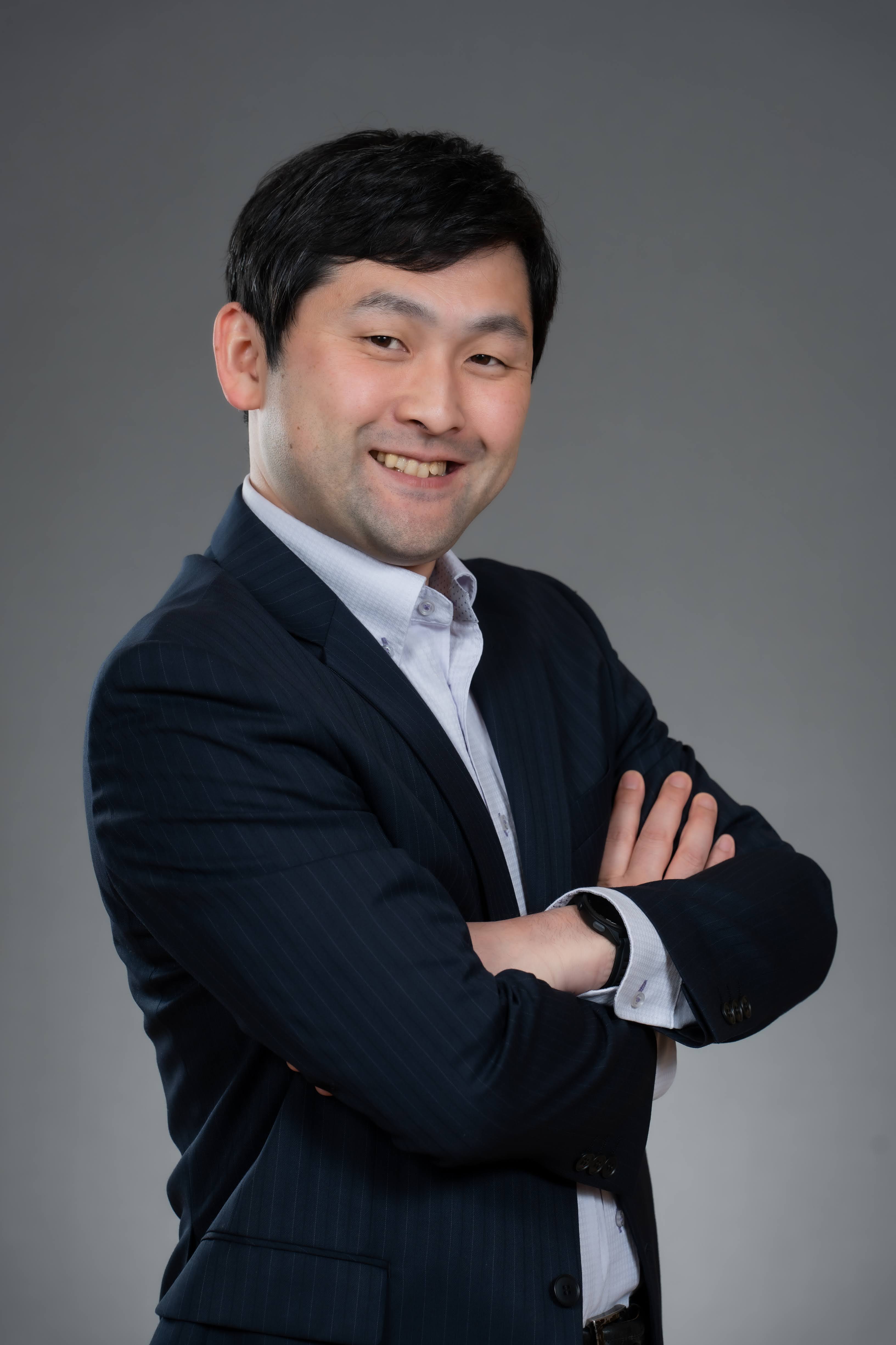A man with arms crossed smiling at the camera