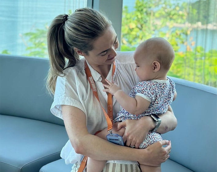 Miranda Mallows sitting down holding her daughter