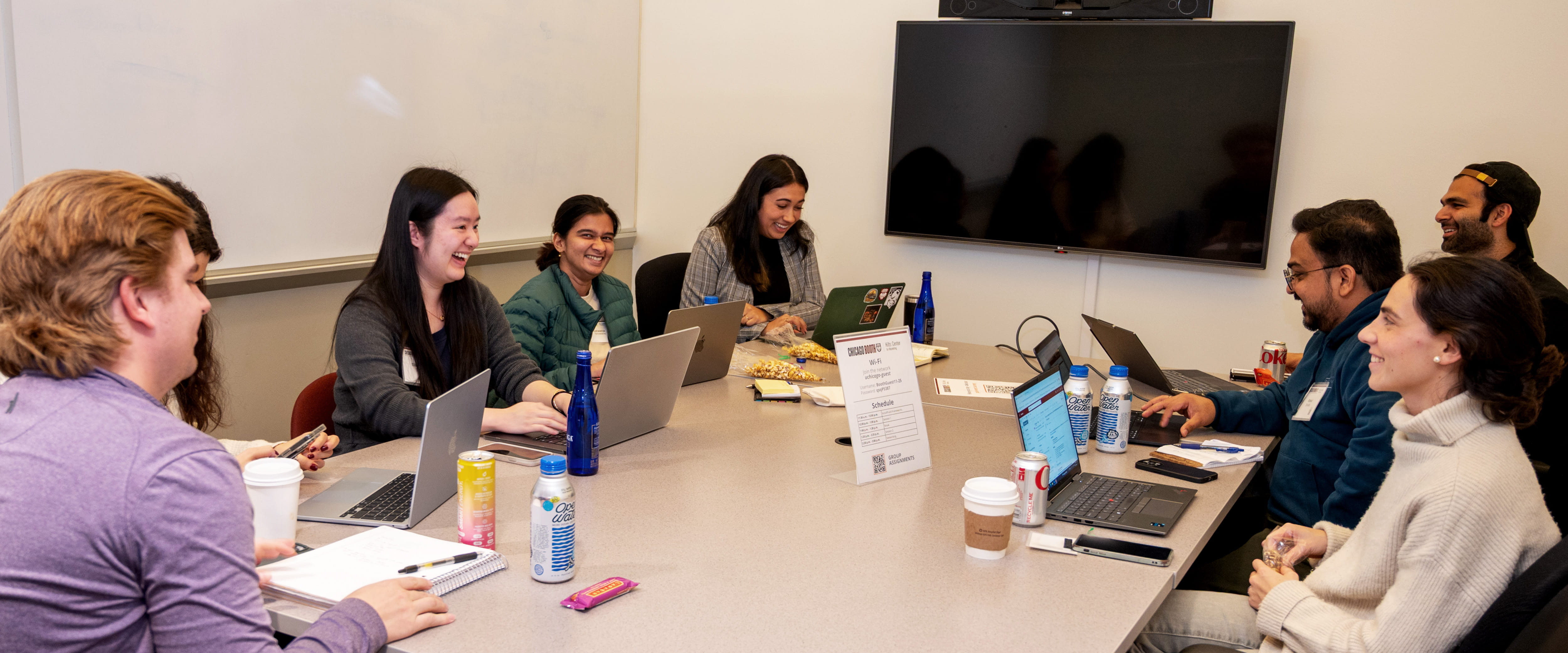 Students with laptops around a table.