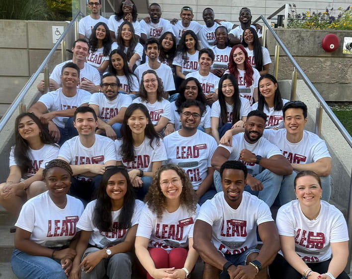 group of students sitting on steps with matching LEAD shirts on