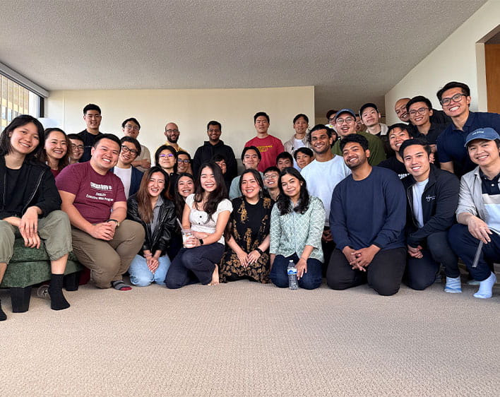 large group of members from the Chicago Asia Pacific group smiling together in apartment living room