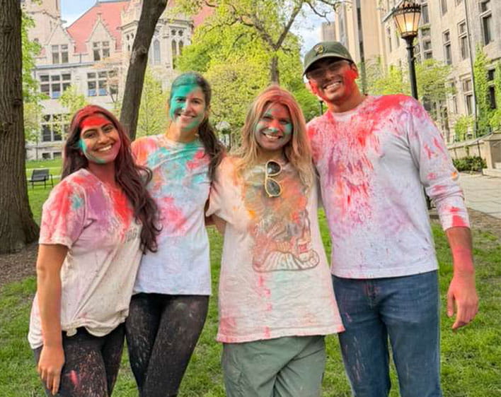 Saniya Kumar and three other Boothies covered in colorful paint from South Asian Business Group event