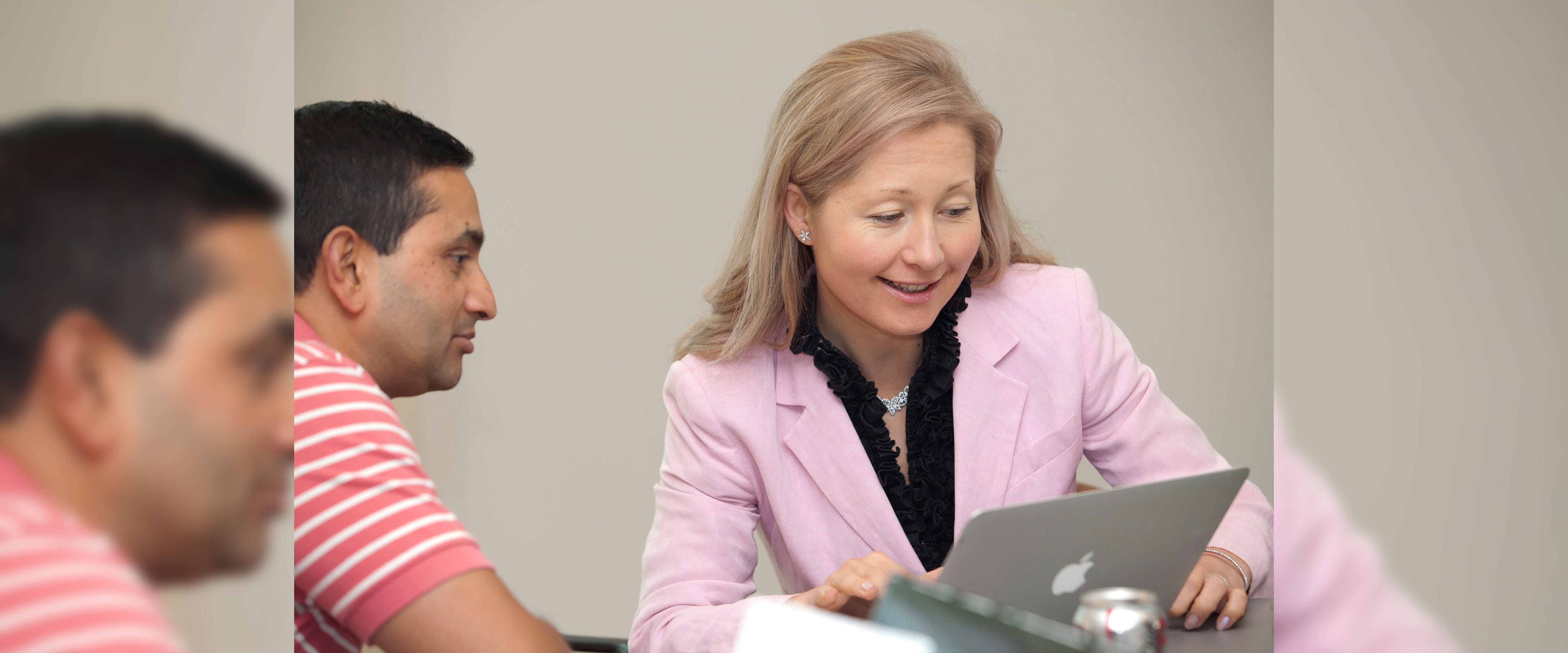 two individuals looking at laptop together