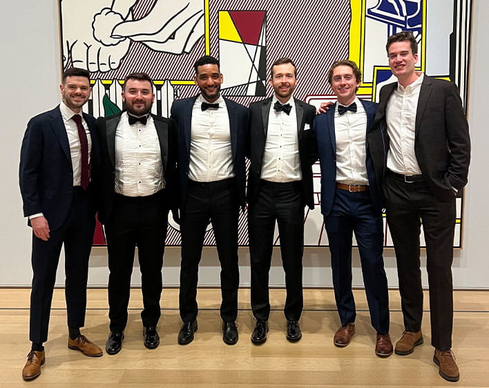 Mayes Lane with a group of friends in tuxedos smiling