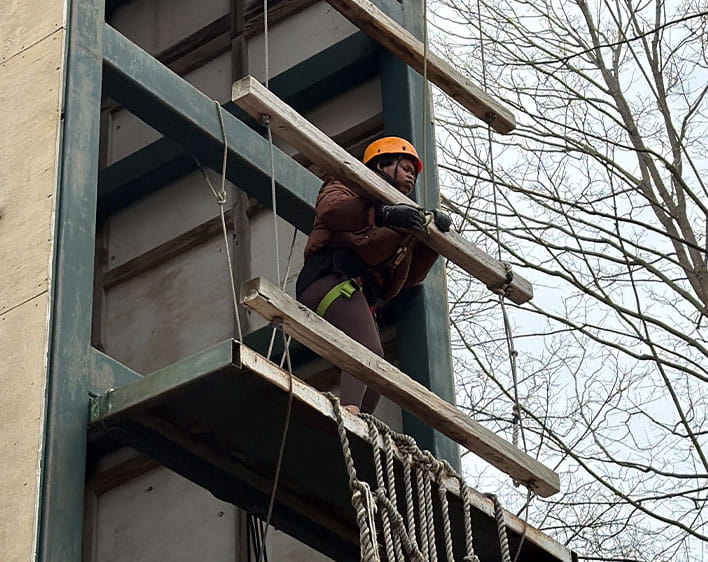 Ude Adekunle suspended in mid-air on a high-ropes course
