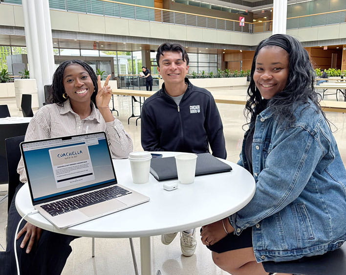 Ude Adekunle with friends in winter garden smiling while sitting at table