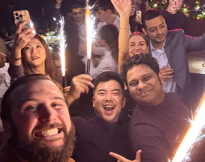 Zachary Hynek with friends celebrating while holding sparklers