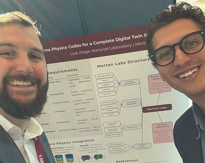 selfie of Zachary Hynek and his co-founder Hamilton in front of poster representing Morton Labs
