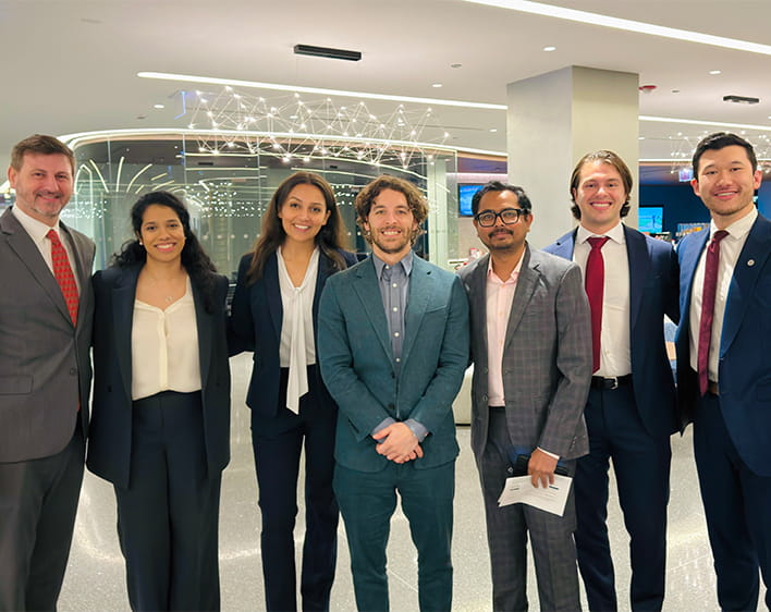 Savita Gupta and group project members smiling in business professional attire