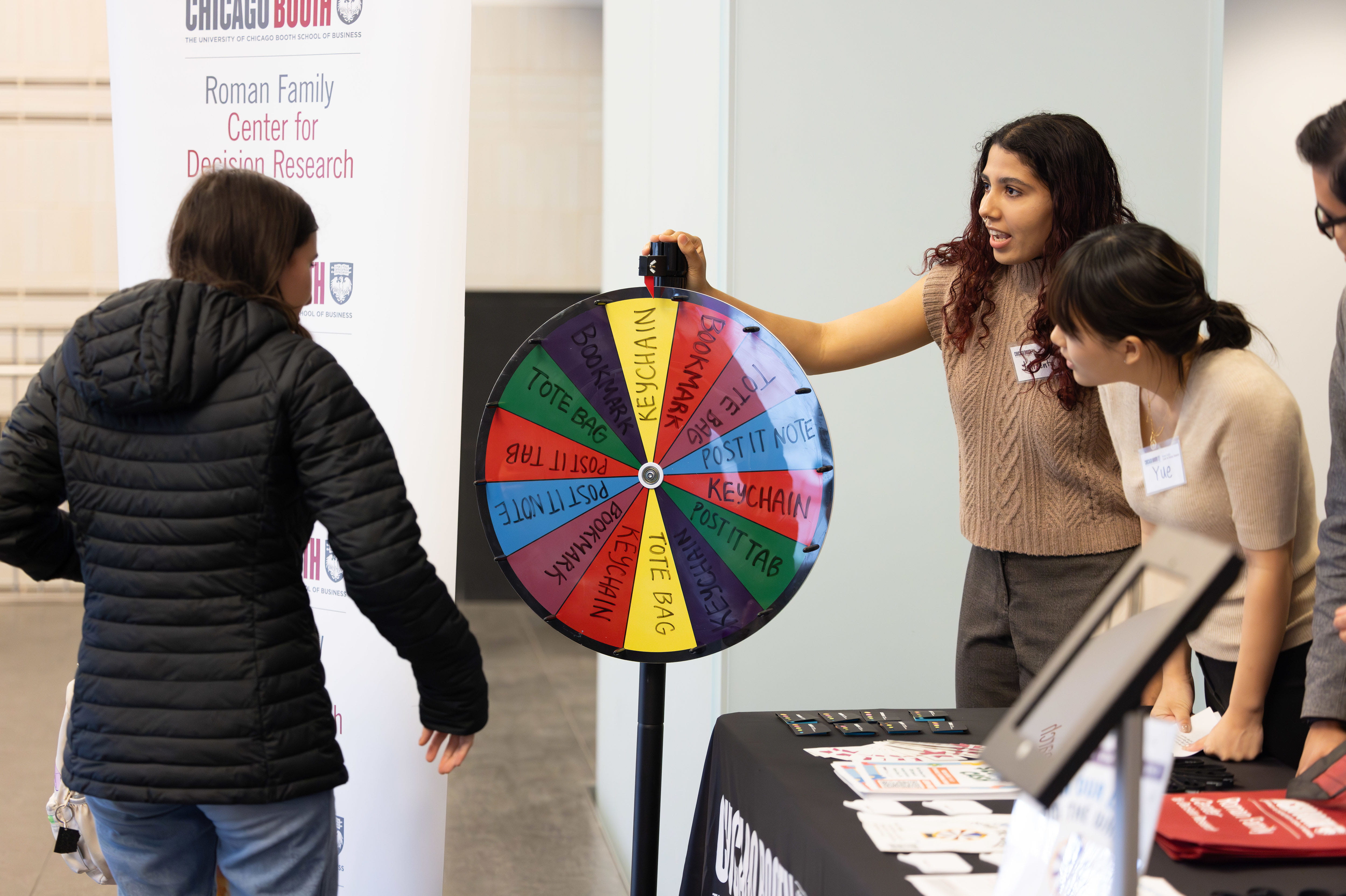 Three people interacting with a spinning wheel