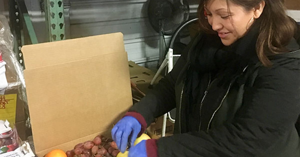 KitcheNet founder Trista Lee packs a box of fresh produce.