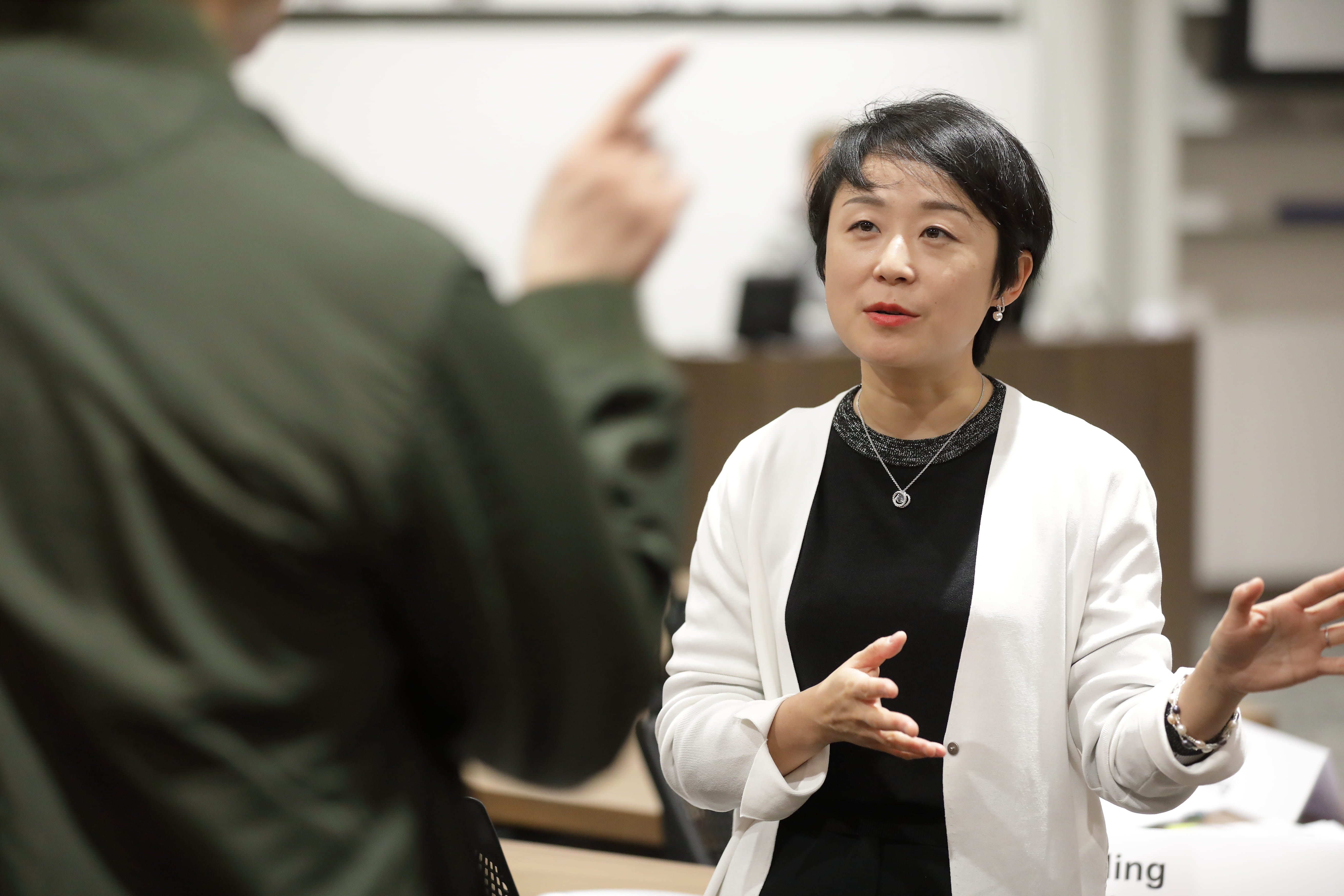 Woman wearing a white coat speaking