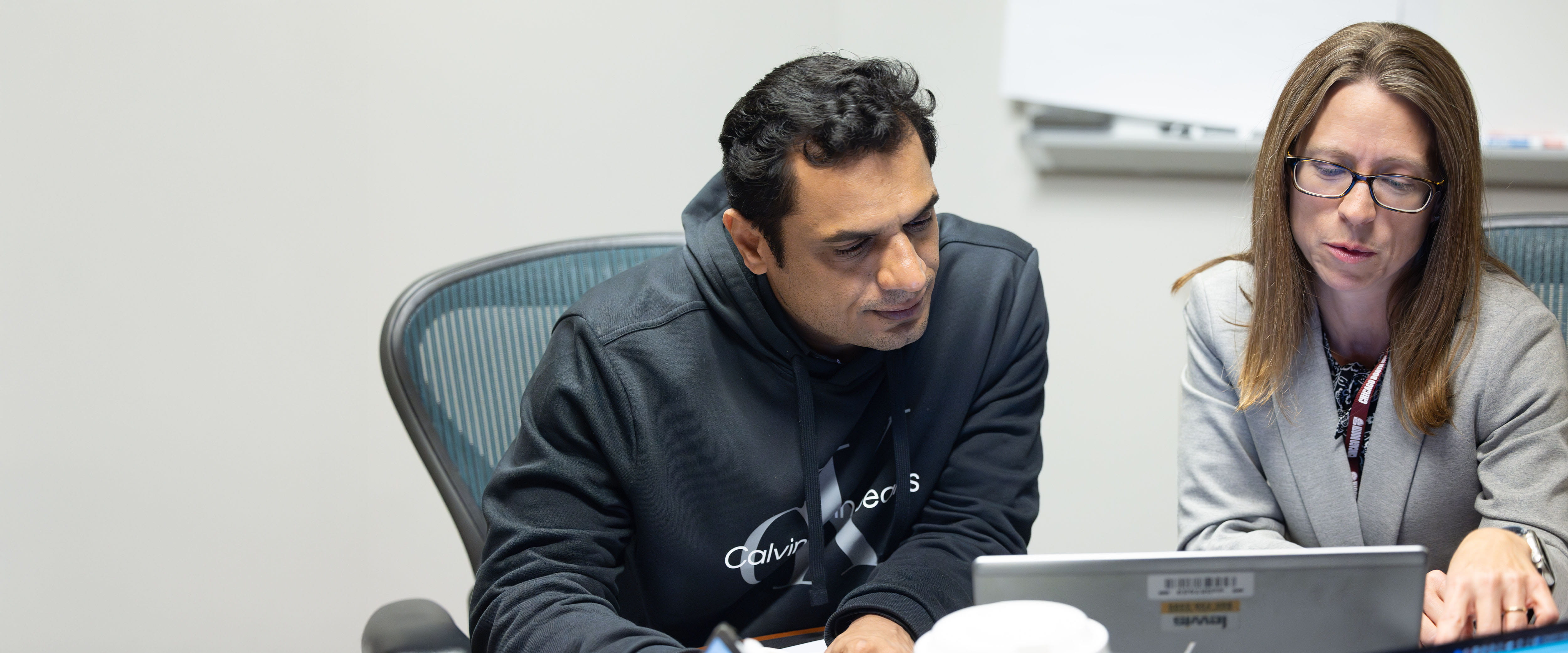 two students looking at laptop discussing