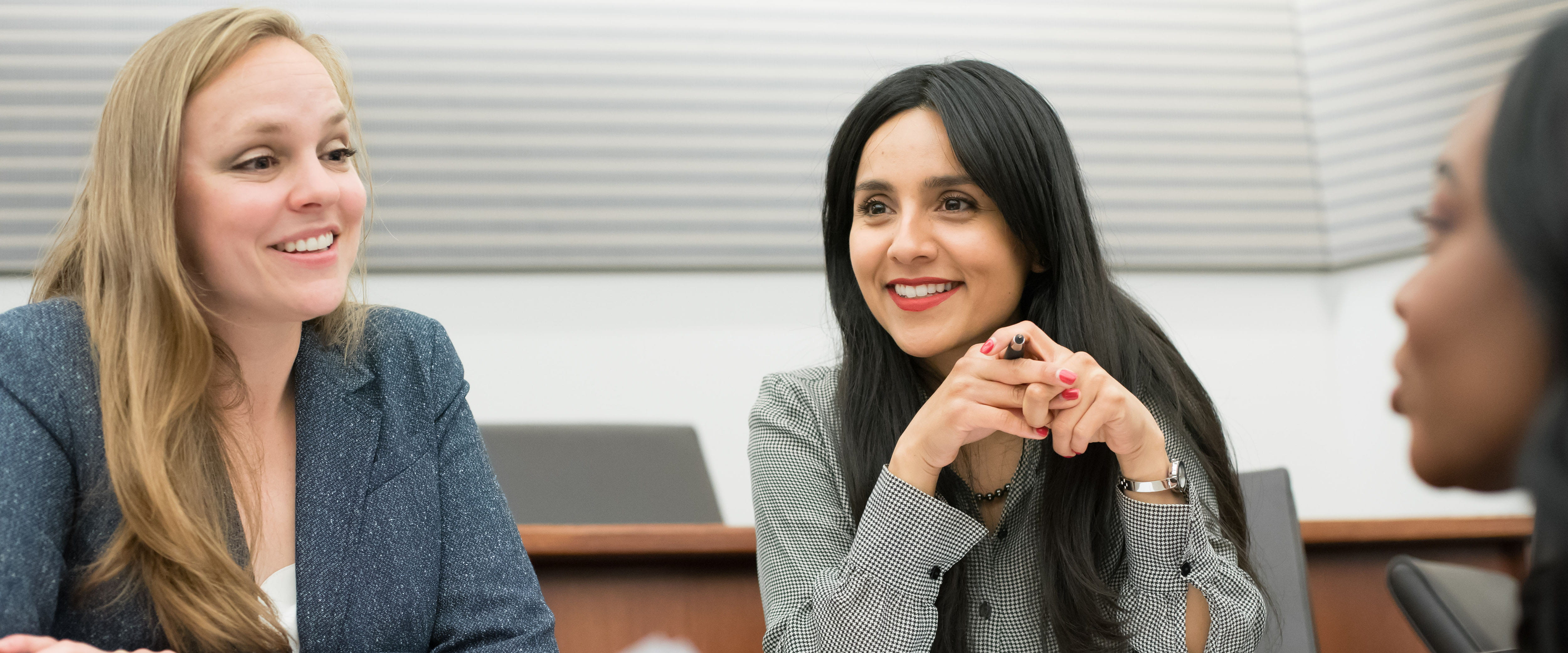 Three students discussing with each other in classroom